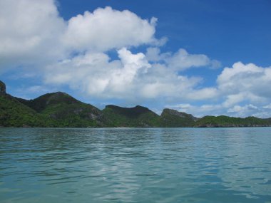Ufukta bulutların ve turkuaz denizin birleştiği mavi gökyüzü.