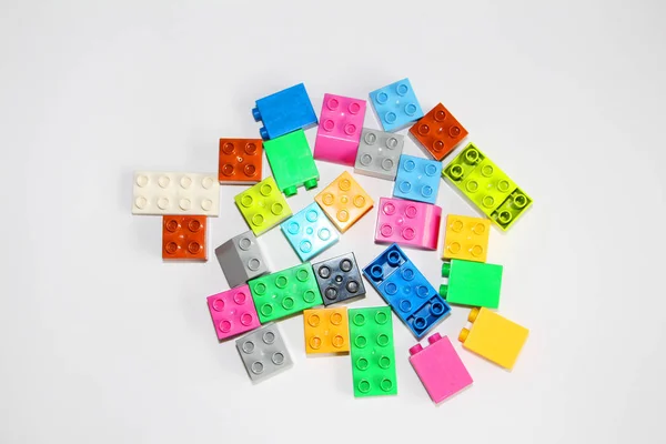 Plastic building blocks on a white background. Multi-colored cubes. — Stock Photo, Image