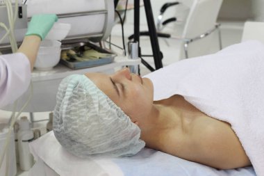 Genç bir kadın güzellik salonunda kozmetik yatakta yatıyor.