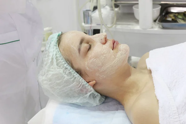 En el salón de belleza una joven está haciendo un peeling en su cara . —  Fotos de Stock