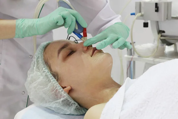 Slipning av huden i ansiktet görs av en kosmetolog i en skönhetssalong. — Stockfoto