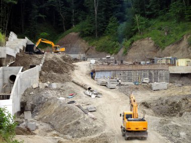 İnşaatçılar ormanın içinden geçerken yolu açıyorlar. Buldozerlerin çalışmaları.