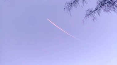 Gökyüzünde yüksekte bir uçak izi var. Uçak kalkıyor. Gökyüzünde havalandırılabilen bir uçağın izini görebilirsiniz. Gece. Bahar.