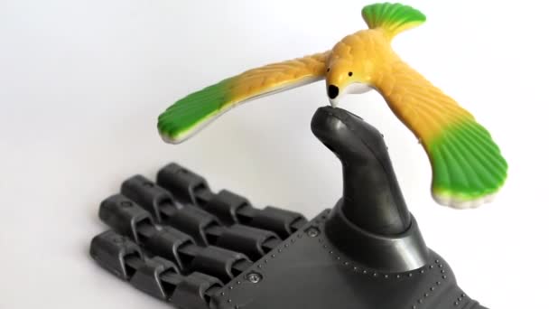 一只小鸟坐在机器人的手指上 鸟是黄色的 它不是活的 但它旋转 机器人手是一种玩具 爱和仁慈的概念 — 图库视频影像