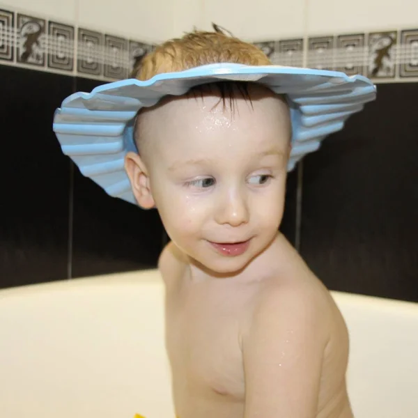 Malý šťastný chlapec v koupelně si myje hlavu. — Stock fotografie