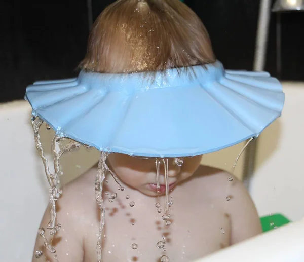 Water is poured over the head of a little boy.