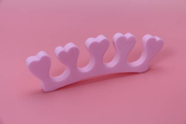Pembe arka plan üzerinde kalpleri ile parmaklar için Manikür ayırıcı.