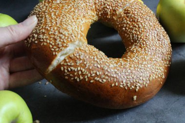 Susamlı taze bir simit. Kadın el bir simit kırAr.