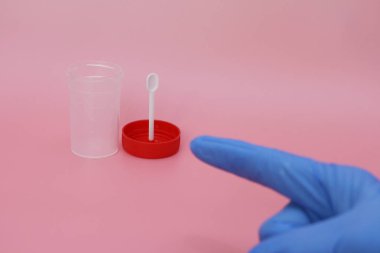 Doktorlar parmak, boş bir dışkı kabını işaret eder..