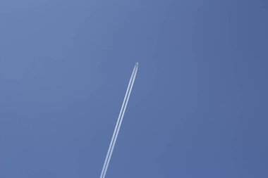 Büyük beyaz bir düzlemin dikey fotoğrafı. Bir uçak gökyüzünde uçar.