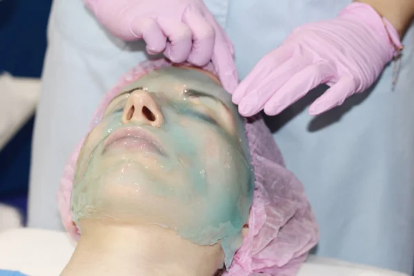 Alginate descascamento máscara facial em pó. Menina faz cara levantando rejuvenescimento . — Fotografia de Stock