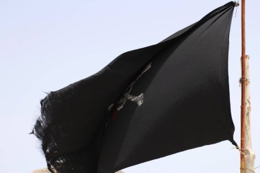 Gökyüzünde eski püskü bir korsan bayrağı beliriyor.