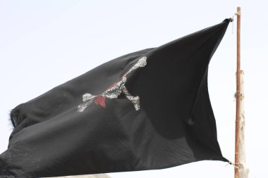 Gökyüzünde eski püskü bir korsan bayrağı beliriyor.