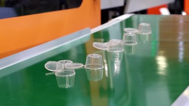 生产一次性塑料餐具 用于生产一次性塑料餐具的工业机器 输送带上新的塑料一次性容器 — 图库视频影像