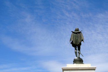 heykelin Alcala de henares, Miguel Cervantes, İspanya memleketi, mavi gökyüzü arka plan üzerine  