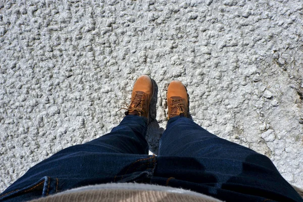 top view of female explorer feet in mountain boots standing on dry surface of salt lake