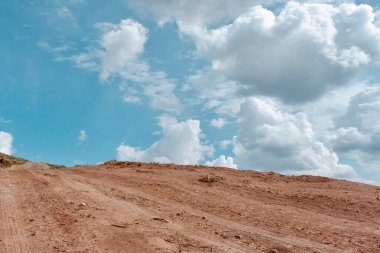 Tepenin tepesine doğru giden dağ yolu hacimli bulutlarla dolu. Kavram: sınırda yürümek, özgürlük, özgürlük