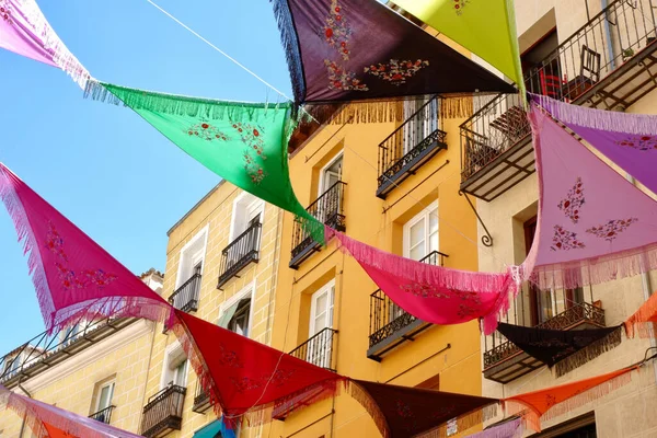 Çok renkli İspanyol şalları dışarıdaki balkonların arasına asılmış. Süslü ortam şenlik havası yaratıyor. La Latina bölgesi, Madrid, İspanya