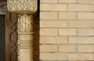 Klasik tasarım detayları: Antik oryantal süslemeli ahşap sütun ve dışarıdan koyu tuğlalı duvar. Kopya uzayı, antika. Madrid, İspanya