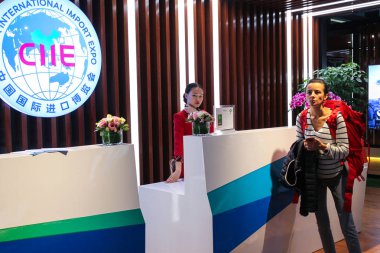 A Chinese hostess serves a foreign visitor in the China International Import Expo Service Center at the Shanghai Hongqiao International Airport in Shanghai, China, 23 October 2018 clipart