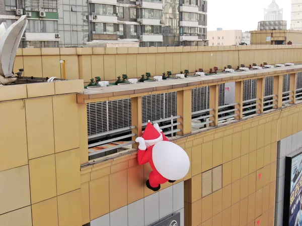 Stock image A toy balloon Santa Claus carrying a giant gift bag is climbing the wall of a department store in Nantong city, east China's Jiangsu province, 1 December 2018.