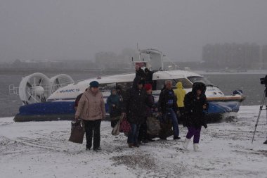 Passengers board a hovercraft to sail to port of Blagoveshchensk of Russia's Amursk in Heihe city, northeast China's Heilongjiang province, 28 October 2018 clipart