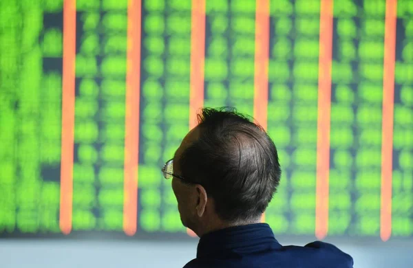 2018 日中国東部の浙江省杭州市の証券会社の家で 赤の価格上昇 と価格下落のため緑の株式の価格を表示する画面を見て懸念している中国語の投資家 — ストック写真