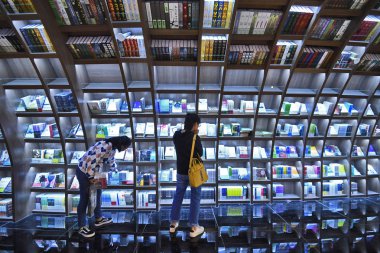 Customers read books at the bookstore Zhongshuge  inspired by local residents due to the unique karst landform in Guanshanhu district, Guiyang city, southwest China's Guizhou province, 4 November 2018 clipart