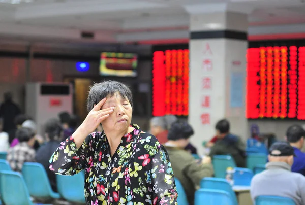 Zainteresowanych Chińskich Inwestorów Patrzy Elektroniczny Wyświetlacz Pokazuje Ceny Akcji Czerwony — Zdjęcie stockowe