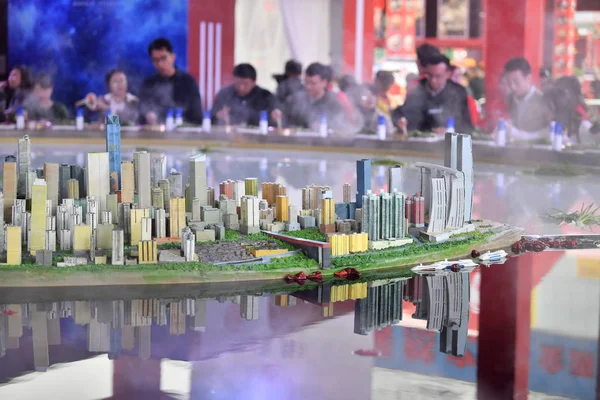 2018年10月19日 在中国重庆举行的火锅美食文化节上 中国顾客在市中心的玉中半岛上的一个巨大的火锅周围用餐 上面装饰着摩天大楼和高层建筑的模型 — 图库照片