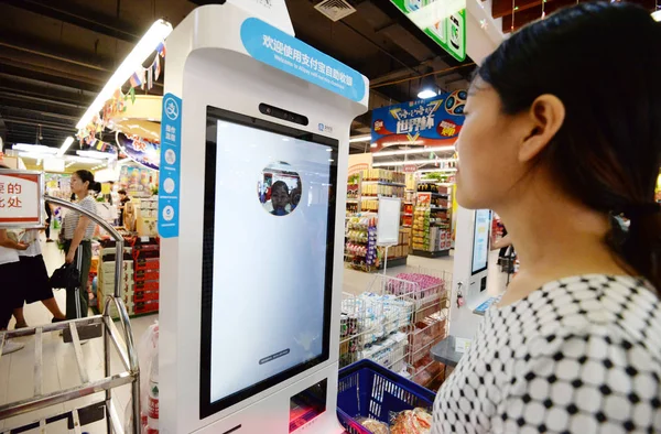 顧客は 中国中部の河北省半安市のスーパーマーケットでアリババグループのアリペイの顔認識決済サービスを利用しています 2018年6月22日 — ストック写真