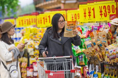 Customers shop for snacks at a supermarket in Taiyuan city, north China's Shanxi province, 16 October 2018 clipart