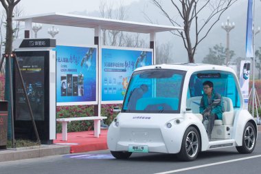 Chinese volunteers take an UISEE self-driving vehicle at the intelligence experience zone for the upcoming United Nations World Geospatial Information Congress (UNWGIC) in Deqing county, Huzhou city, east China's Zhejiang province, 20 November 2018.  clipart