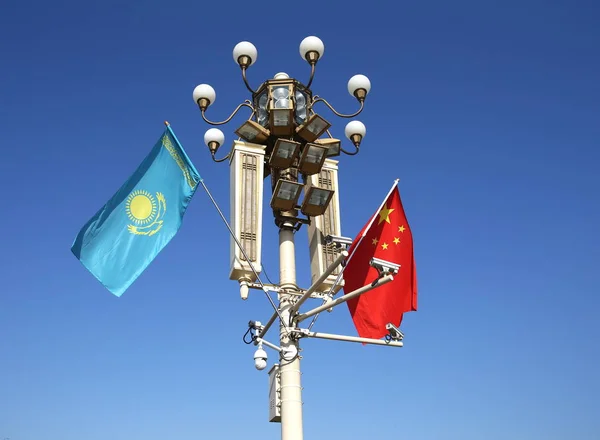 Bandeiras Nacionais Chinesas Cazaques Agitam Poste Luz Frente Rostro Tian — Fotografia de Stock