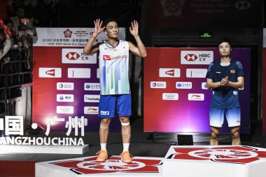 Kento Momota of Japan, left, and Shu Yuqi of China attend the awarding ceremony after their Men's Singles final match during the HSBC BWF World Tour Finals 2018 in Guangzhou city, south China's Guangdong province, 16 December 2018 clipart