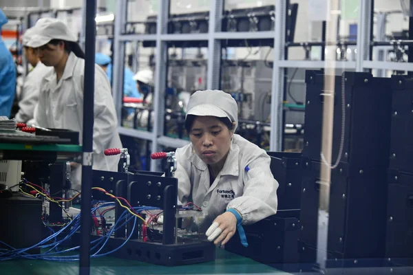 中国の労働者は 2018 日中国南西部の貴州省遵義市の工場での組立ラインでインテリジェントな製品を製造します — ストック写真