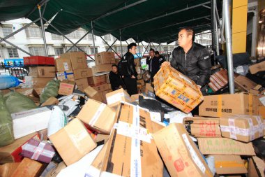 Chinese workers sort out parcels, most of which are from Singles' Day online shopping, at a distribution center in Shaoxing city, east China's Zhejiang province, 18 November 2018 clipart
