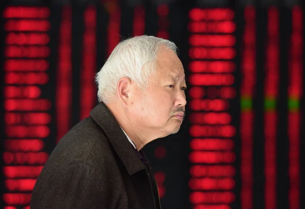 Филе Китайский Инвестор Проходит Мимо Экрана Показывающего Цены Акции Красный — стоковое фото