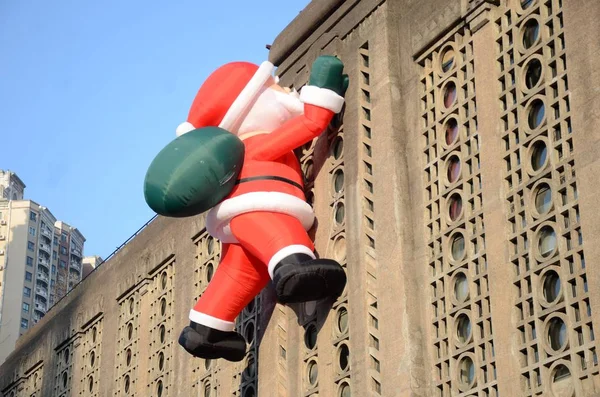 Toy Balloon Santa Claus Carrying Giant Gift Bag Climbing Wall — Stock Photo, Image