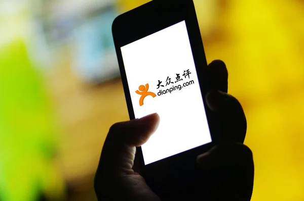 Ein Handynutzer benutzt die mobile App des Restaurant-Bewertungsdienstes dianping auf seinem Smartphone in der Stadt ji 'nan in der ostchinesischen Provinz shandong, 20. April 2017 — Stockbild Ein Handynutzer Benutzt Die Mobile App Des Restaurant Bewertungsdienstes Dianping — Stockfoto