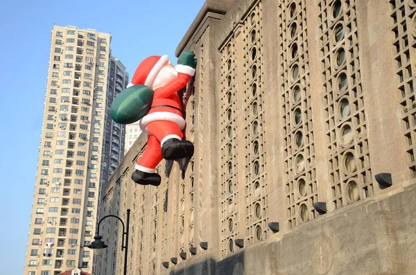 Toy Balloon Santa Claus Carrying Giant Gift Bag Climbing Wall — Stock Photo, Image