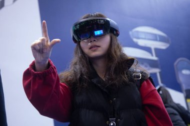 A visitor experiments Augmented Reality (AR) using HoloLens glasses during the United Nations World Geospatial Information Congress (UNWGIC) in Deqing county, Huzhou city, east China's Zhejiang province, 20 November 2018.  clipart