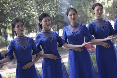 Chinese volunteers wearing cheongsam (qipao) pose for photos ahead of the upcoming Fifth World Internet Conference (WIC), also known as Wuzhen Summit, in Wuzhen town, Tongxiang city, Jiaxing city, east China's Zhejiang province, 1 November 2018 clipart