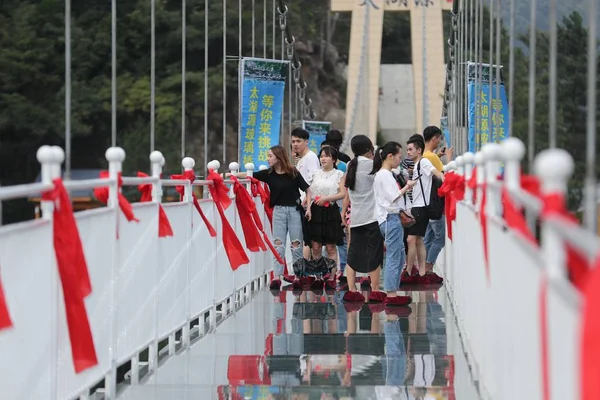 2018年9月6日 在中国东部浙江省杭州市临安区太湖源风景区 游客们走在 层高的玻璃底悬索桥上欣赏风景 — 图库照片