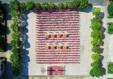 Young Chinese students hold up national flags they made by themselves to celebrate the National Day holiday and the 69th anniversary of the founding of the People's Republic of China at a primary school in Jiapu town, Changxing county, Huzhou city, e clipart