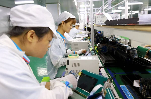 中国人労働者は中国の四川省南西部の Huaying 市の工場でスマートフォンやその他の電子製品の部品を生産しており 8月7日2018 — ストック写真