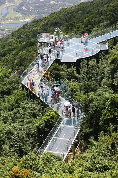観光客は 南中国の海南省 三亜市の亜龍湾熱帯楽園の森公園で 400メートルの長いガラスの底の空の歩道を歩きます 月2018 — ストック写真