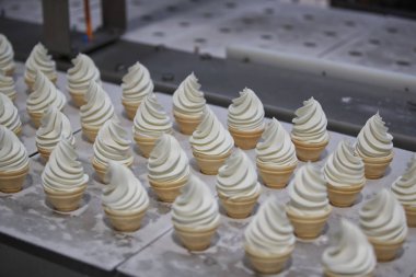Yili torch ice creams are being produced on the assembly line at a factory of state-owned dairy company Yili Group in Beijing, China, 19 July 2018.  clipart