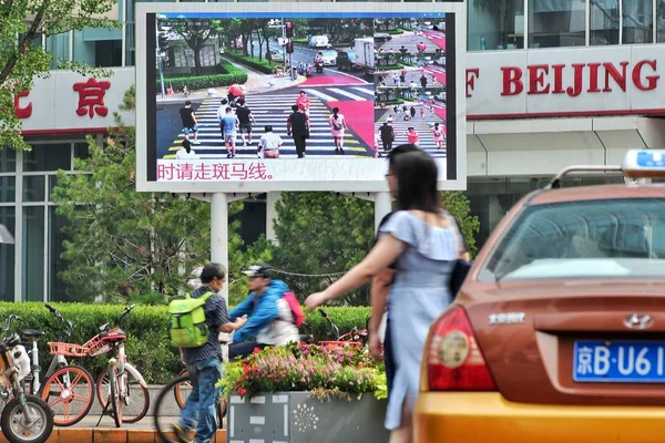 Pedestres Atravessam Uma Encruzilhada Como Uma Tela Grande Apoiada Pelo — Fotografia de Stock