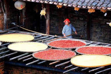 Chinese villagers dry hot peppers, corns, chrysanthemum flowers, and other crops and harvests on racks under the sun in Huangling village, Wuyuan county, Shangrao city, east China's Jiangxi province, 16 September 2018 clipart